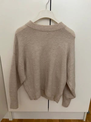 Stickad tröja - Stickad biege tröja med pärlor 