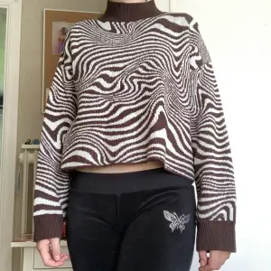 En croppad, stickad tröja med ett coolt mönster