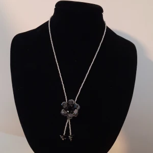 Smycken - Superfint halsband med svart blomma och matchande ring.  150 kr/ styck ellrt båda för 200. Hör gärna av dig vid frågor eller funderingar