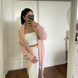 Cardigan - Stickad lång cardigan i jättesöt rosa färg. Koftan är i Huddinge jättebra skick, använd endast några gånger. Säljer då den inte kommer till användning hos mig🫶🏻