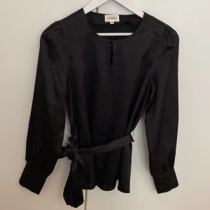 Dranella blus - Svart blus från Dranella, knyts med ett band i midjan. Storlek XS/34. Använd 1 gång och är i perfekt skick.