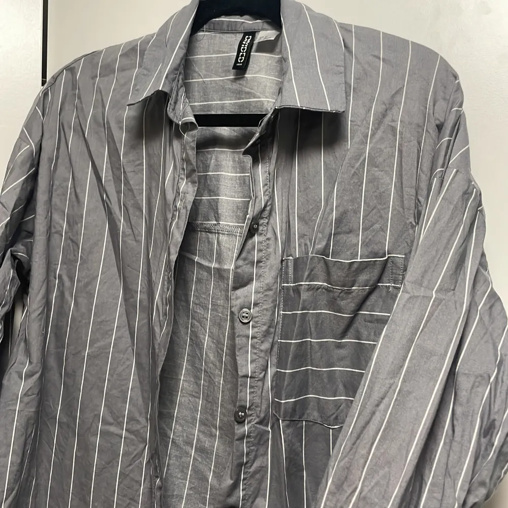 Randig gråvit skjorta i storlek XS men som ni ser är den oversize (passar alla upp till storlek L) den är använd ett par gånger men är som ny i skick. Lite skrunklig men det är bara att stryka👍🏼. Skjortor.