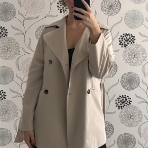 Kort trenchcoat  - Säljer denna korta trenchcoaten från H&M, superfint skick! Kommer ej till användning längre. Nypris 699kr🍁