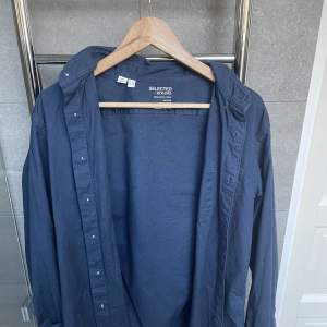 Säljer nu denna snygga blåa skjortan från selected home. Skjortan är perfekt nu till sommaren och sitter riktigt bra på en. Det är storlek M men skulle kunna 