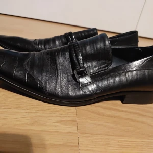 Skor - Svart skor som använder en gång. 