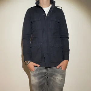 Filippa K Jacka  - Flippa K fieldjacket - storlek S men kan passa större beroende på hur man gillar passformen - varan är i jätte fint skick men har en defekt (saknar en knapp på axeln) - modellen är 188cm och 83kg - vid frågor eller funderingar är det bara att skriva!