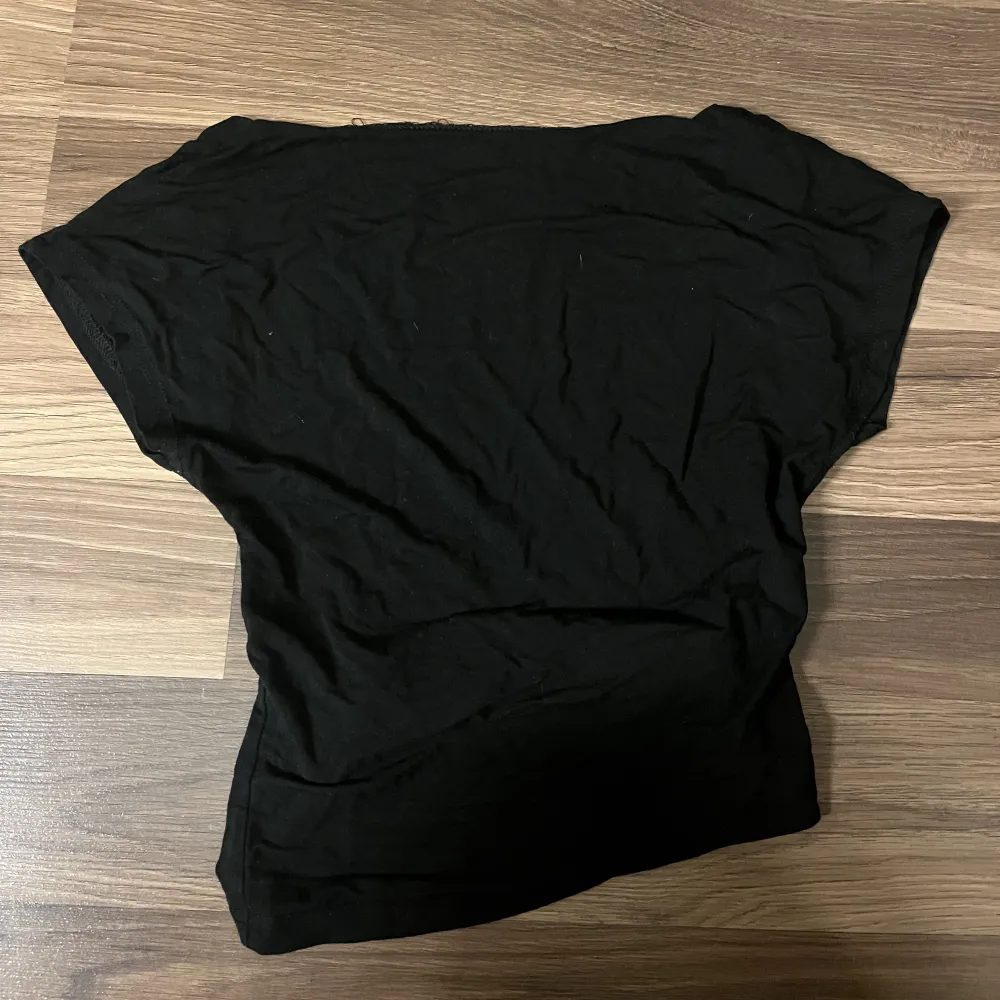 En svart T-shirt med öppen rygg.. Toppar.
