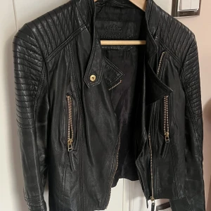 Primeboots skinnjacka - Äkta skinnjacka från Primeboots. Använd men fortfarande i fint skick förutom det som syns på bild nr 3. Guldetaljer. 🤗❤️  Inköpt för runt 3000kr men säljs billigt för jag vill bli av med den. 