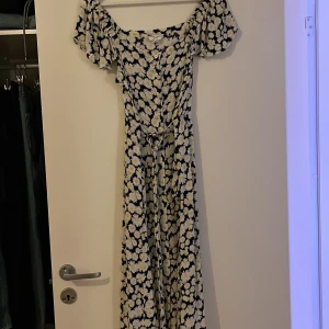 Klänning  - Fin klänning med blommor Fickor i sidorna och band att knyta baktill eller åt sidan.  Storlek 40