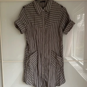 Skjortklänning  - Snygg med ett svart skinnbälte i midjan eller bara som den är oversized. Storlek S, skulle säga att den är normal i storleken. Ärmen kan man knäppa upp eller vika ner nästan till armbågen 🫶