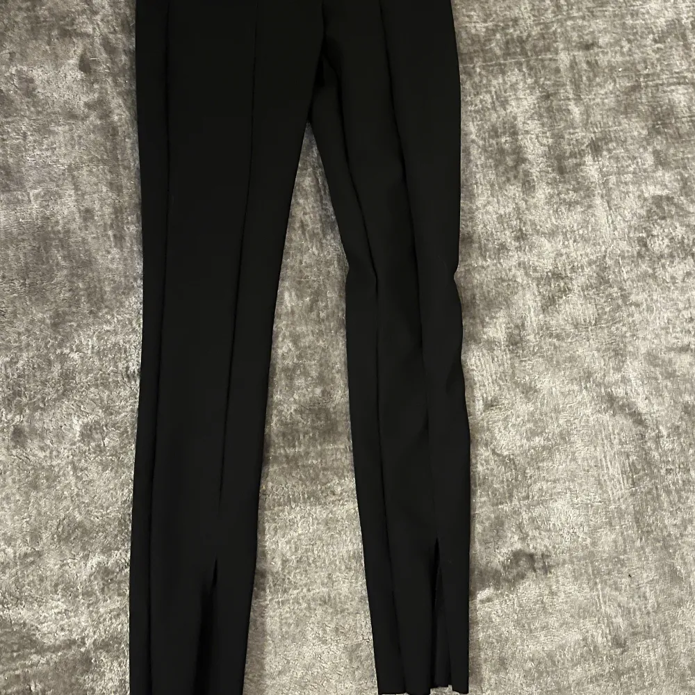 Ett par svarta kostym tights med sömmar och slit . Jeans & Byxor.