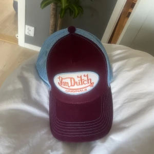 Keps från von dutch - En jättesnygg keps från von dutch. Den är vinröd och blå. 
