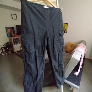 Low waist cargo pants. - Grå lågmidjade cargo-byxor med flera fickor. Mjukt prassligt material. Midjan går att dras åt. Storlek XS men passar även S.  Byxor i gott skick men höger ben saknar ett elastiskt snöre i sömmen. Inget som är något problem om inte man är kort,, som mig,,