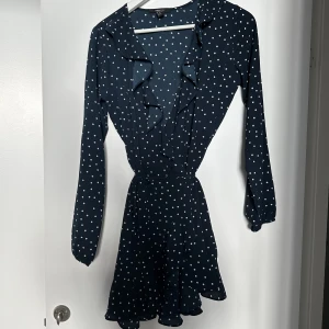 Klänning - En fin mörkblå klänning med vita prickar på. Den är från Forever 21, i storlek M.