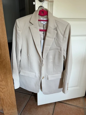 Beige kavaj  - Super fin, helt oanvänd beige kavaj från NAKD, perfekt nu till sommaren. Perfekt Overzied fit. Storlek 34