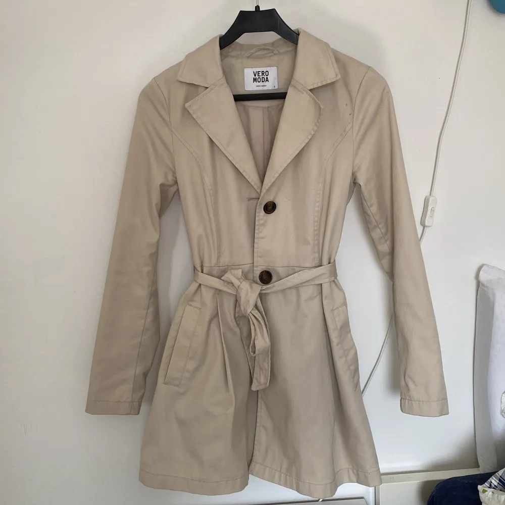 Säljer en ljusbeige trenchcoat från Vero Moda i storlek S!  (Den är något ljusare i verkligheten). Jackor.