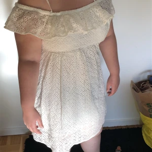 Vit klänning i Stl 40. Student klänning. Skolavslutning klänning. Sommar klänning. Midsommar - En fin vit klänning perfekt för studenten, skolavslutning, midsommar och vardagen! Klänningen är använt vid ett tillfälle och är i fint skick. Den är gjord av bomull och har utskurna blom detaljer runt om hela klänningen. Klänningen är i stl 40