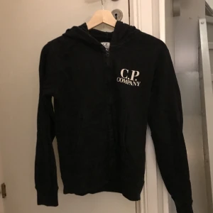 Cp company hoodie  - Tjena jag säljer en cp company Hoodie i storlek 12 år /152cm med glasögon på ryggen som man ser på den sista bilden. Den är använd ett fåtal gånger. Ny pris 2200kr