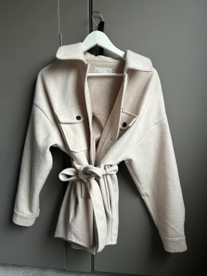 Beige kappa - Kappa från NLY TREND i storlek 36, passar en XS/S om man vill ha lite oversized. Kappan slutar ungefär nedanför rumpan 🌸