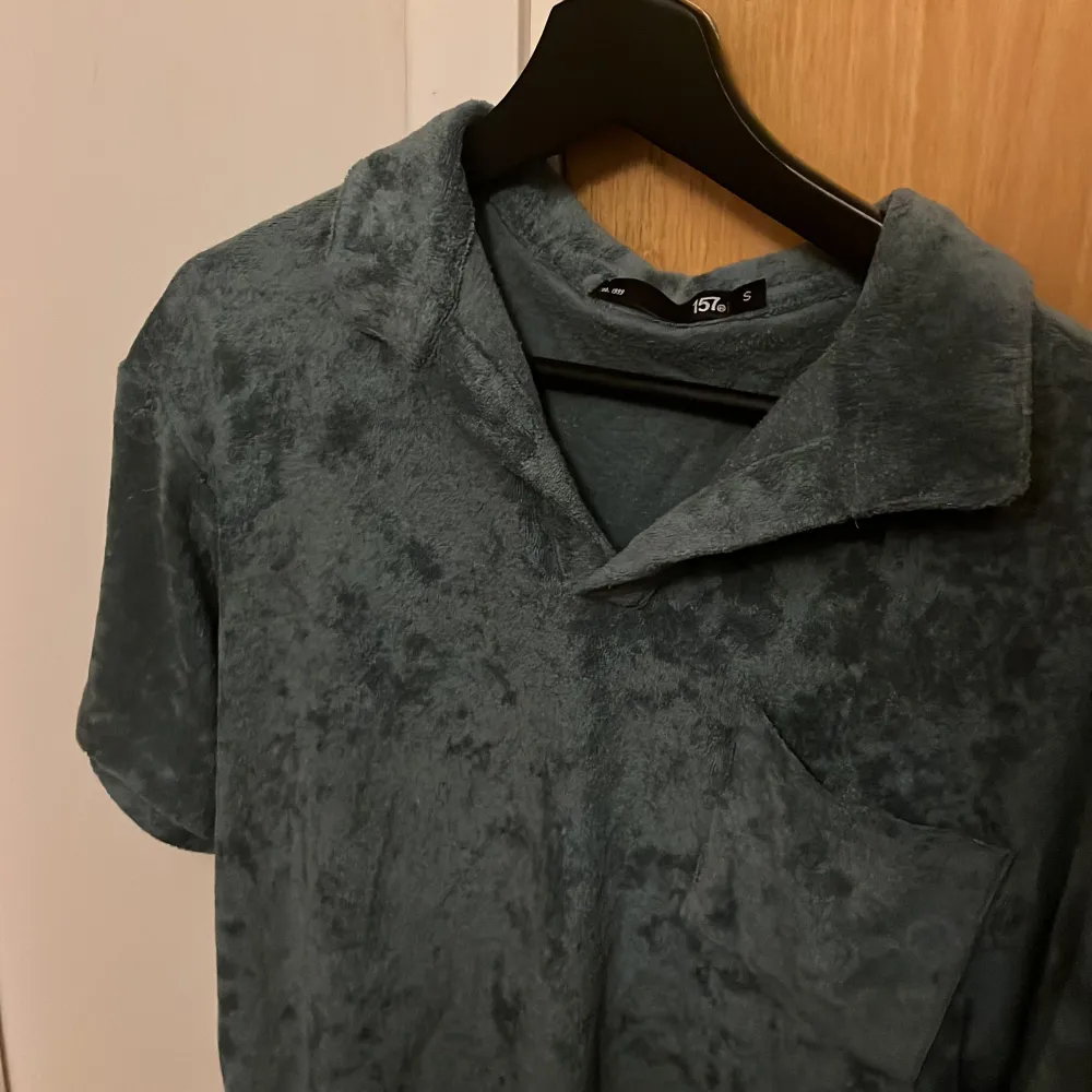 Det är en mörk grön t-shirt. Köpt för 200kr på lager 157. Använd några gånger. Det är som handduks material.. T-shirts.