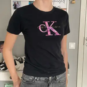 Jag säljer en fin och tajt Calvin Klein tröja, den är svart med ett litet lila rosa tryck. Säljer för 10 kr