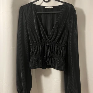 Svart blus från pull&bear - Helt ny blus från Pull&bear i storlek S. Snyggt glansigt material och låg v-ringning