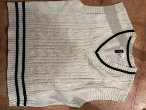 Vit stickad väst - Vit stickad väst med svarta linjer längst kanterna endast använd 1 gång