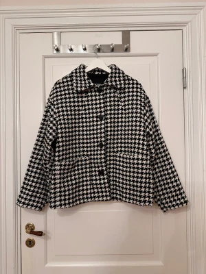 Mönstrad jacka från Monki - Mönstrad jacka från Monki i storlek i storlek XS. Strukturvävd. Fickor på framsidan, stängs med knappar. Oversized men inte på mig som är vanligtvis M, utan sitter ”normalt” på. Svart och vit. Använd ett fåtal gånger. 