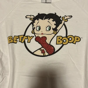 Betty Boop t-shirt - Betty boop t-shirt med strass. Sååå fint skick och knappt använd med säljer då jag har för mycket kläder💗 Storlek M men sitter även fint på mig som har S.