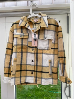 Gul skjortjacka  - Helt ny skjortjacka i gul rutigt tryck från Kids Only med prislappen kvar.  Storlek 152.  Kan skickas men köparen betalar frakten.  Vid intresse kan fler bilder skickas.  Nypris: 500kr Mitt pris: 200kr Först till kvarn gäller.  