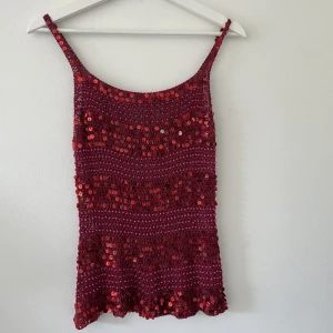 Glitter- och paljettlinne - En röd och glittrig partytopp av paljetter! Går att ha utan BH enligt mig, inte så seethrough! 