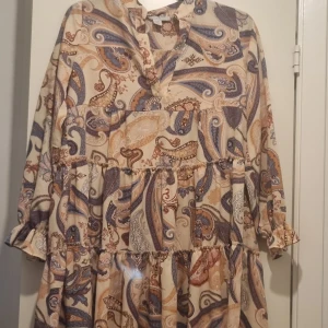 Paisley mönstrad tunika - Rosa söt Paisley mönstrad tunika/klänning. Stor i modellen. Volangigt nedtill och skönt härligt msterial i tyget till sommaren och hösten med.