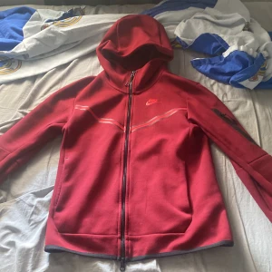Nike Röd tech fleece  - En fin och oanvänd kofta från Nike köpt för 1300 säljs nu för 800, dessa modeller är fina och säljs inte längre. Den är XS men de är stora i storlekarna kan passa dig med S.