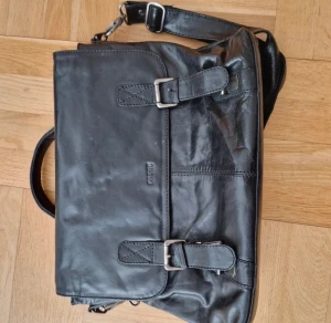 Portföljväska - Svart portföljväska med inbyggd datorfodral. Inga defekter och är perfekt för skola eller jobb med praktiska och rymliga fickor!