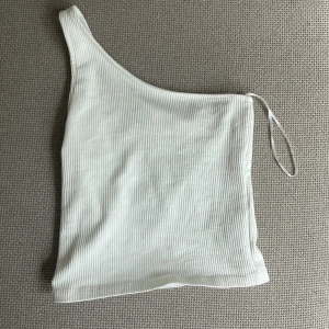 Oneshoulder top - Vit top från Gina som inte kommer till användning länge. Stretchig i tyget och inte alls genomskinlig
