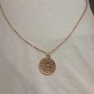 Guldigt halsband - Halsbandet är helt oanvänd.  Kedjan är 50,5 cm. Den borde inte färga av sig vid kontakt med vatten eller av nån vätska. Funkar bra till alla tillfällen. Köpt på Ur&Pen 