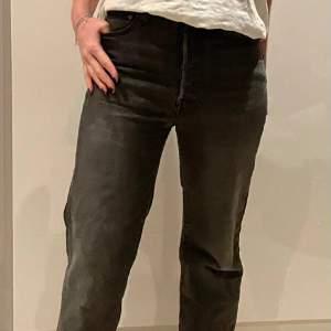 Gråa Levi’s jeans i modellen ribcage straight i bra skick. Jeansen har fransar längst ner.