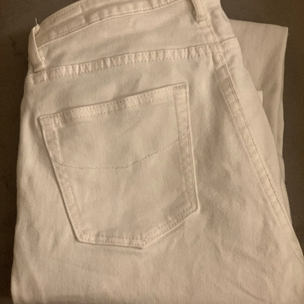 Säljer ett par super snygga vita lågmidjade jeans men fina ditaljer på bakfickorna! Lite för långa för mig som är 173. Hör av dig vid frågor eller funderingar💗. Jeans & Byxor.