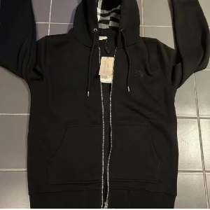 Burberry hoodie - Den är i väldigt bra skick. Varför jag säljer den så billigt är för att dragkedjan är utbytt då orginal gick sönder. Kom privat för fler bilder, Pris kan diskuteras vid intresse!