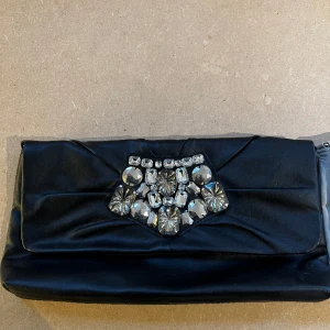 Portmonnä väska - Svart portmonä väska med stenar.  