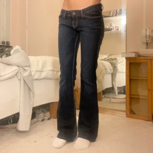 Lågmidjade jeans - Skit snygga mörkblåa lågmidjade bootcut jeans från Guess med coola detaljer på bakfickorna 
