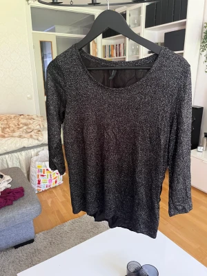 Blus - Glittrig blus i svart och silver, använd få gånger. I väldigt fint skick.