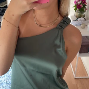 Fest topp zara  - Grön satin topp från zara, använd fåtal gånger. Går att använda åt båda håll. Fått en liten fläck men inget märkvärdigt och som inte går att ta bort. 