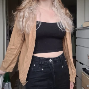 Kort cardigan - En kort cardigan i storlek L, ser ändå bra ut om man har mindre storlek. Notera ärmlängden. Ärmen blir kortare på en större storlek. Jag själv är XS/S för referens  Använd ett fåtal gånger, mycket fint skick 