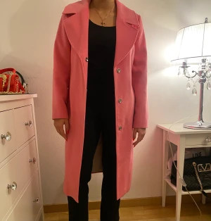 Rosa kappa - En lång rosa kappa från zalando. Är i storlek 40. Endast använd ett par gånger.