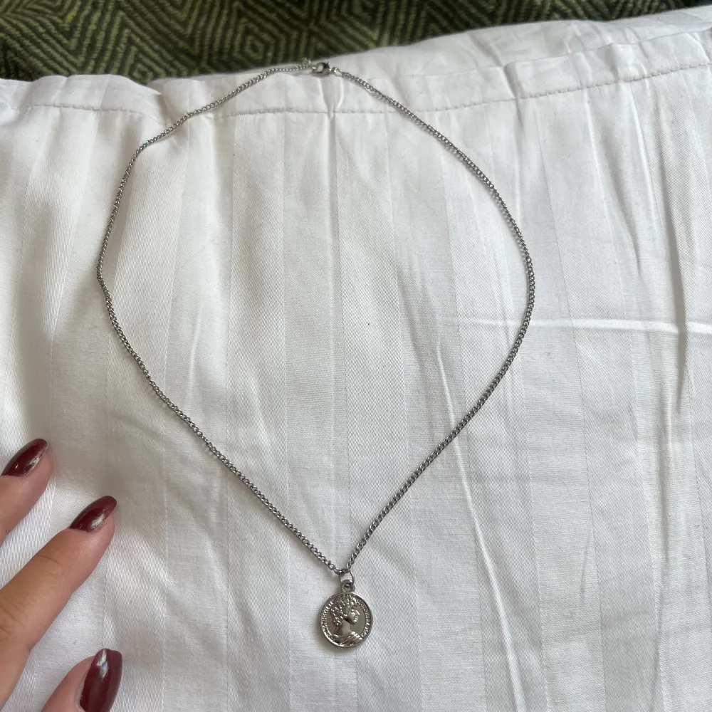 halsband med ett litet smycke. ungefär 60 cm. knappt använd, ser helt nytt ut!. Accessoarer.