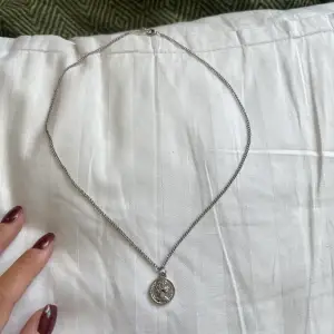 halsband med ett litet smycke. ungefär 60 cm. knappt använd, ser helt nytt ut!