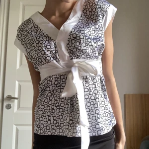 Blus - Så fin v-ringad blus med vita snören man kan knyta till en rosett längst fram eller bak. Perfekt att styla tillsammans med en mini kjol🤍🌟 Nyttskick!