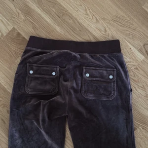 Bruna Juicy Couture byxor - Byxorna är i storlek S men passar även M, byxorna är i gott skick och använda fåtal gånger. Snöret har åkt ut men finns kvar som ses på bilden:) köparen står för frakten 