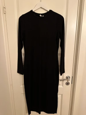 Skön ribbad lång, svart klänning - Svart lång ribbad klänning. Mjukt ribbat material medel tjockt material. Aldrig använt. Normal i storleken.   Ord. Pris 299kr